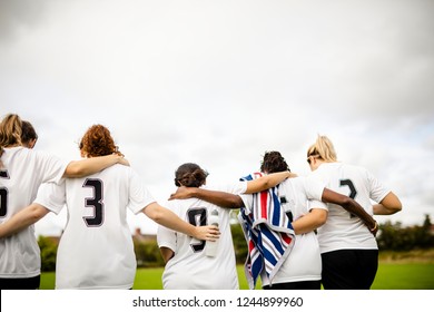 Female football players huddling and walking together - Powered by Shutterstock