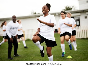 Female football players warming up on the field - Powered by Shutterstock