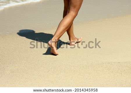 female foots footprints in the sand on the beach in summer