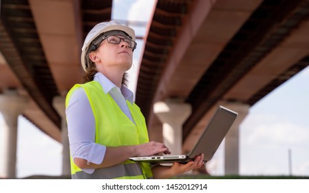 female foreman inspects object at building site. Construction of central ring car road. - Shutterstock ID 1452012914