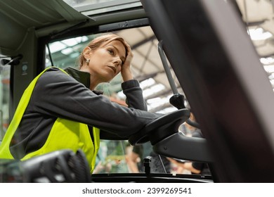 Female forlklift driver feeling overwhelmed from amount of work. Tired, exhausted warehouse worker preparing products for shipmennt, delivery, checking stock in warehouse. - Powered by Shutterstock