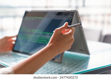 Female freelance developer coding and programming. Coding on two with screens with code language and application.