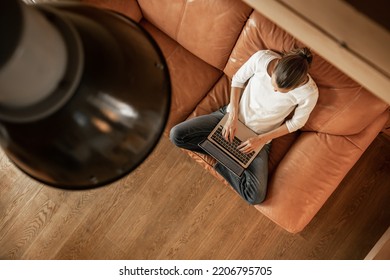 Female Freelancer Using Laptop Computer Sitting On Sofa At Home. Technology Freelance Career And Lifestyle Concept. Top View Shot, Panorama 

