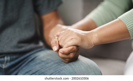 Female friend or family sitting and hold hands during cheer up to mental depress man, Psychologist provides mental aid to patient. PTSD Mental health concept