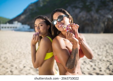 Female Friends At Beach Party. Two Women In Colorful Swimsuits, Smiling, Eating Ice Cream. Party, Outdoor Activity, Friendship Concept