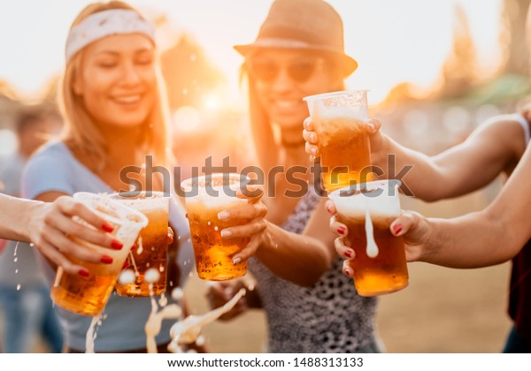 Female\
friends cheering with beer at music\
festival