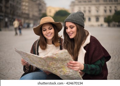 Female Friends Consulting A City Map In The Winter