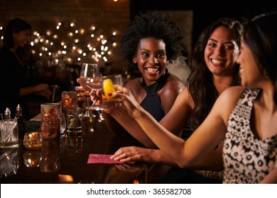 Female Friends Enjoying Night Out At Cocktail Bar