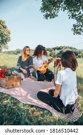 Female Friends Enjoying A Picnic In Nature.