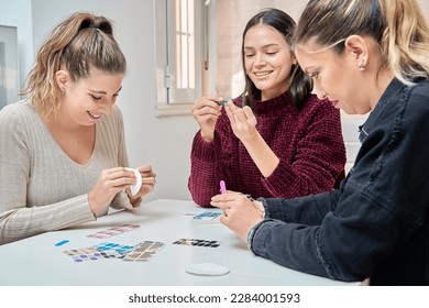 Female friends having fun while doing their nails together. Manicure and friendship concept.
