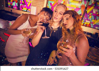 Female friends having glass of champagne and wine against flying colours