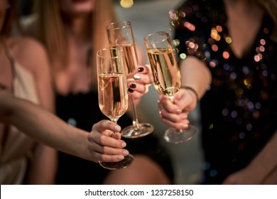 Female Friends Make Toast As They Celebrate At Party. Group Of Partying Girls Clinking Flutes With Sparkling Wine