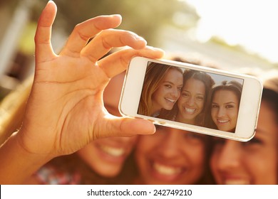 Female Friends On Holiday Taking Selfie With Mobile Phone