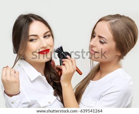 Female friends putting makeup 