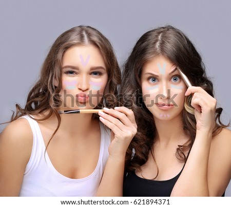 Female friends putting makeup  . Contouring.Make up woman face