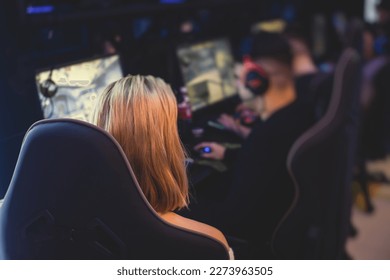 Female gamer, cyber sport e-sports tournament, professional girl gamers, close-up on gamer's hands on keyboard, pushing button,  in a cyber games arena club, girls playing and streaming fps game