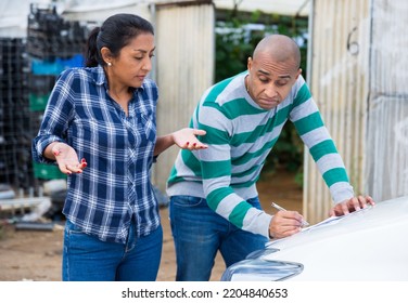 Female Gardener Discussing Contract For Transportation Of Agricultural Products With Representative Of Transport Company Outdoors Against Background Of Greenhouses