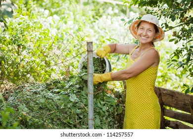 Female Gardener Making Compost In Garden