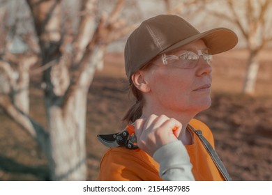 Female Gardener Posing With Hand Pruner In Walnut Orchard Ready For Pruning, Woman Farmer Using Pruning Shears