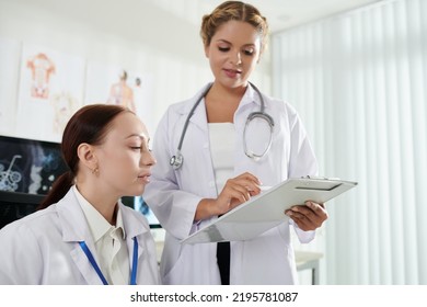 Female General Practitioner Asking Colleague To Help Her With Patients Diagnosis