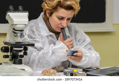Female geologist researcher analysing a rock at her workplace.