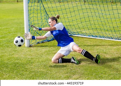 Female goalkeeper saving a goal during a game - Powered by Shutterstock