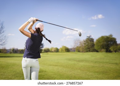 Female golf player swinging golf club. - Powered by Shutterstock