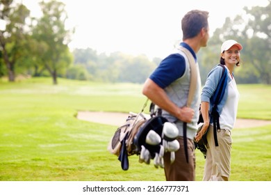 Female golfer smiling and looking at man. Focus on female golfer smiling and looking at man.