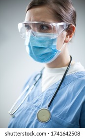 Female GP Doctor In Blue Uniform,headshot Portrait,isolated On White Background,side Profile Perspective,worried Anxious Tired & Overworked Medical Frontline ICU Staff Working Long Shifts In Hospital