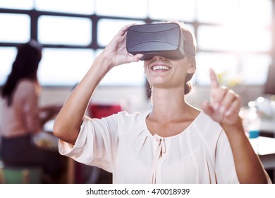 Female Graphic Designer Using The Virtual Reality Headset At Office