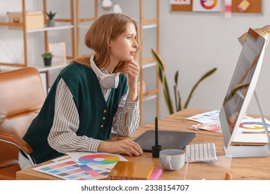 Female graphic designer working with computer at table in office
