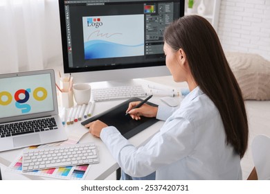 Female graphic designer working with tablet at table in office - Powered by Shutterstock