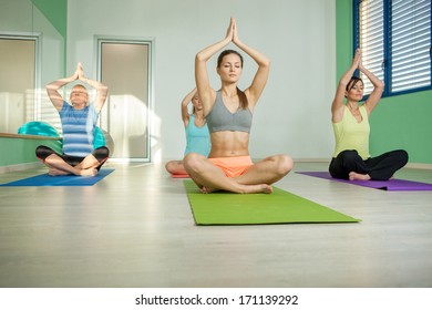 Female group is doing yoga exercises in a fitness club