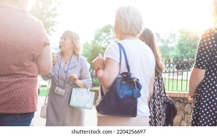 female guide is telling a group of tourists about something. - Shutterstock ID 2204256697