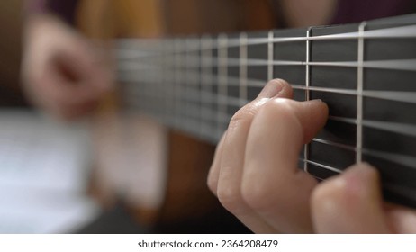 Female Guitarist Playing Song on Classical Guitar Close Up - Powered by Shutterstock