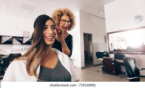 Female Hair Dresser Working On Styling A Woman 's Hair. Hairdresser In A Happy Mood While Working On A Woman's Hair Style.