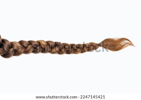 Female hair in the form of a braid on a white isolated background. Red hair braided close-up. Beautiful healthy natural female hair without dyeing Foto d'archivio © 