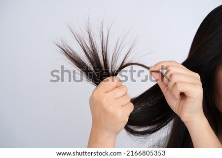 Female hair with split ends on a white background.
