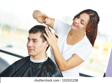 Female hairdresser cutting hair of smiling man client - Powered by Shutterstock