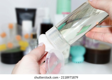 A Female Hand Applies Tonic, Face Toner With An Inverted Bottle With Other Care Cosmetics