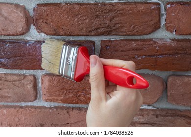 Female Hand Applies Varnish To A Decorative Facing Brick.