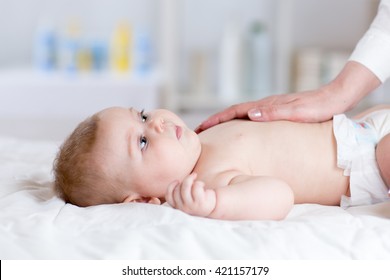 Female hand with baby infant lying on bed in living room