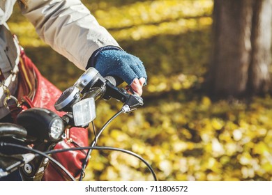 Female hand with beautiful manicure in a blue woolen mittenspresses the brake lever on the handlebars autumn day close-up - Shutterstock ID 711806572