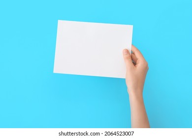 Female hand with blank paper on color background - Shutterstock ID 2064523007