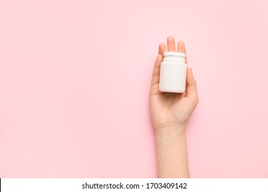 Female Hand With Bottle Of Pills On Color Background