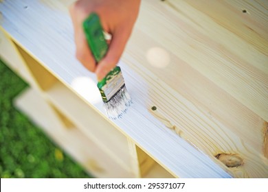 Female Hand With Brush Painting Wooden Furniture.