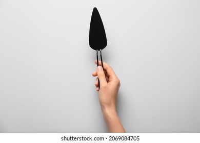 Female Hand With Cake Spatula On Light Background