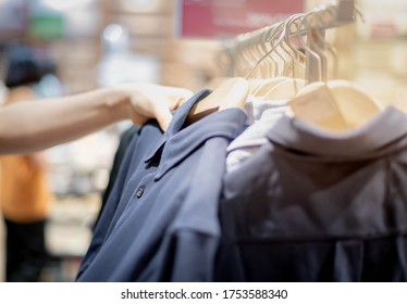 Female Hand Choosing Clothes For Checked Pattern Cotton Polo Shirt On The Rack In Cloth Shop At Department Store. Check Price, Discount And Promotion Of Clothing Product.