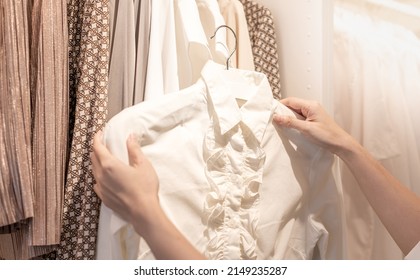 Female Hand Choosing Clothes For Checked Pattern Cotton Polo Shirt On The Rack In Cloth Shop At A Department Store. Check Price, Discount, And Promotion Of Clothing Products.