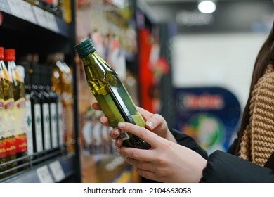 Female Hand Choosing Natural Olive Oil At Store. Concept Of Healthy Food, Bio, Vegetarian, Diet.